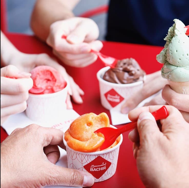 Friends enjoying multiple Bachir Ice Cream flavours in cups during summer in Dubai
